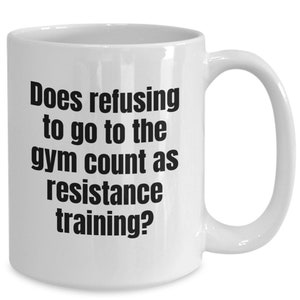 May include: White ceramic coffee mug with black text that reads "Does refusing to go to the gym count as resistance training?"