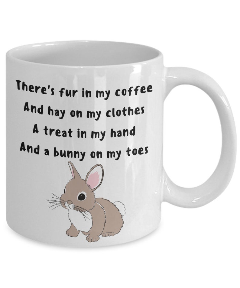 May include: White ceramic mug with black text: "There's fur in my coffee, And hay on my clothes, A treat in my hand, And a bunny on my toes." A cartoon bunny illustration is also on the mug.