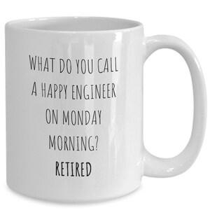 May include: White ceramic coffee mug with black text that reads: "What do you call a happy engineer on Monday morning? Retired."