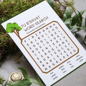 May include: A white card with a brown and green border featuring a word search puzzle for Tu B'Shvat. The puzzle includes words like "grapes," "date," and "fig." A tree graphic is in the upper left corner. The card is surrounded by greenery.
