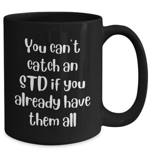 May include: Black coffee mug with white text that reads "You can't catch an STD if you already have them all".