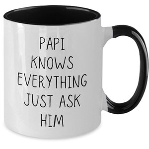 May include: White ceramic mug with a black interior, handle, and rim. The mug features the text "PAPI KNOWS EVERYTHING JUST ASK HIM" in black, centered on the front. A simple, yet thoughtful gift.