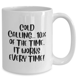 May include: White ceramic coffee mug with black text that reads "Cold Calling... 10% of the time, it works every time!"