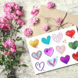 Può includere: Un biglietto con una varietà di cuori colorati disegnati in diversi stili. I cuori sono decorati con motivi, punti e linee. Il biglietto è circondato da rose rosa.
