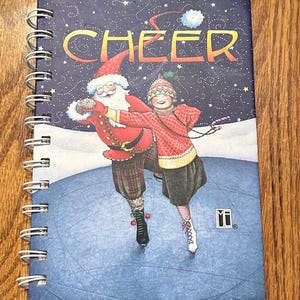 Diario vintage de Mary Engelbreit con papel rayado, encuadernado con alambre y cubierta de cartón, con el tema de patinaje sobre hielo y Papá Noel