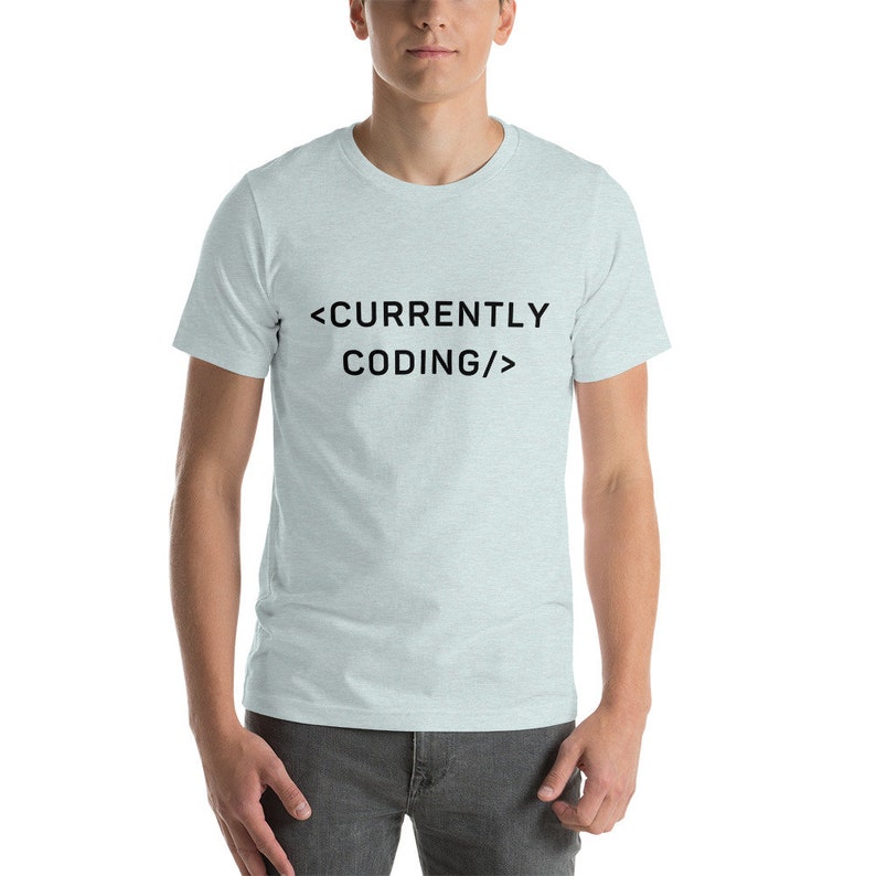 Op de afbeelding: Een lichtblauw t-shirt met de tekst "<CURRENTLY CODING/>" in zwart.