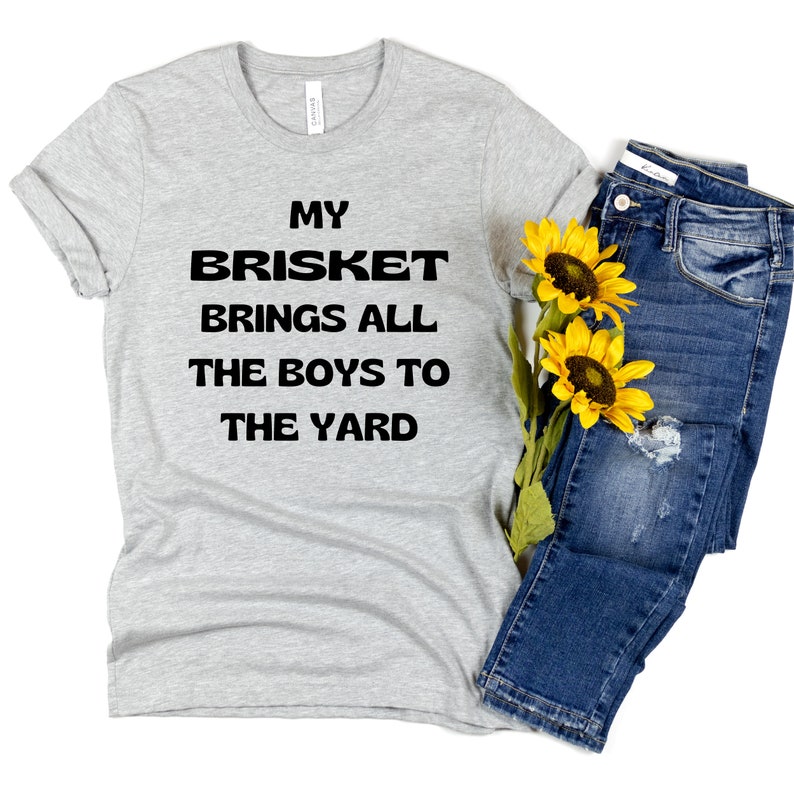 May include: A gray t-shirt with the text "My Brisket Brings All The Boys To The Yard" printed in black.