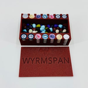 May include: A red foam insert with compartments for storing game pieces. The insert is labelled "WYRMSPAN" and contains a variety of colourful game pieces.