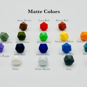 May include: A chart of 16 different colours of matte geometric shapes. The colours include army brown, lava red, desert red, muted green, army green, forest green, savannah yellow, sunrise orange, lavender purple, army blue, marine blue, sapphire blue, muted blue, pink, white, white marble, grey, and black.
