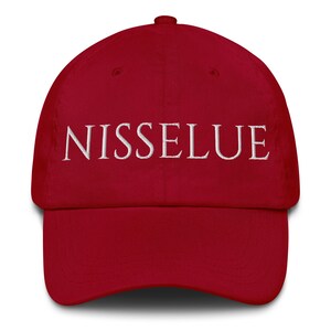 May include: A deep red baseball cap with the word "NISSELUE" embroidered in white across the front. The cap has a curved brim and a rounded crown. The hat is made of a soft, durable material.