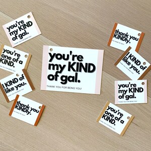 May include: A set of eight gift tags with various messages printed on them. The tags are brown, beige, and white with black text. The messages include "you're my kind of gal", "you're one of a kind", "I kind of like you", and "thank you kindly".