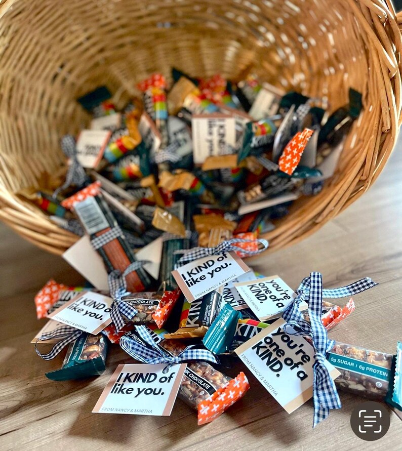 May include: A wicker basket overflowing with individually wrapped granola bars, each tied with a ribbon and a small tag that reads "I kind of like you."