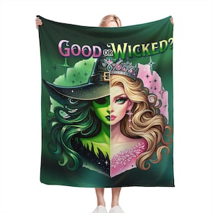 Peut inclure: Une couverture vert foncé avec un motif divisé. D'un côté, une sorcière à la peau verte avec un chapeau noir, de l'autre, une femme blonde avec une couronne. Le texte "GOOD OR WICKED?" est affiché en rose et vert.