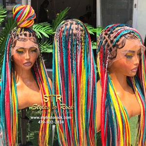 May include: A colorful braided wig with a bun on top. The braids are a mix of red, yellow, blue, and pink. The wig is on a mannequin head. The text "STR Styles to Rock" is visible.