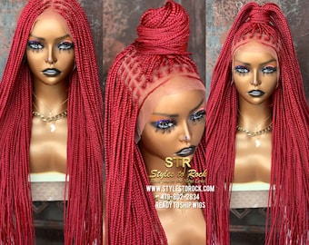 May include: A red braided wig with a lace front. The wig is styled with a high bun on top. The wig is ready to ship.
