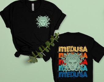 May include: Black t-shirt with a green Medusa graphic on the front pocket and a repeated Medusa graphic with the word "MEDUSA" in a rainbow color scheme on the back.