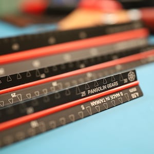 May include: Close-up of a black ruler with red markings and the text "Pangolin Gears" and "Made in Taiwan".
