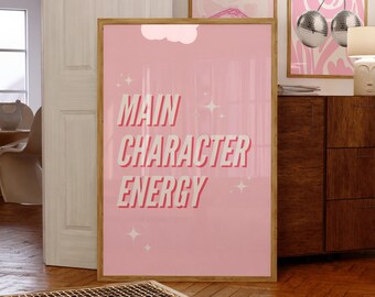 May include: Pink and white poster with the text "MAIN CHARACTER ENERGY" in bold red letters. The poster is framed in wood and has a cloud shape in the background.