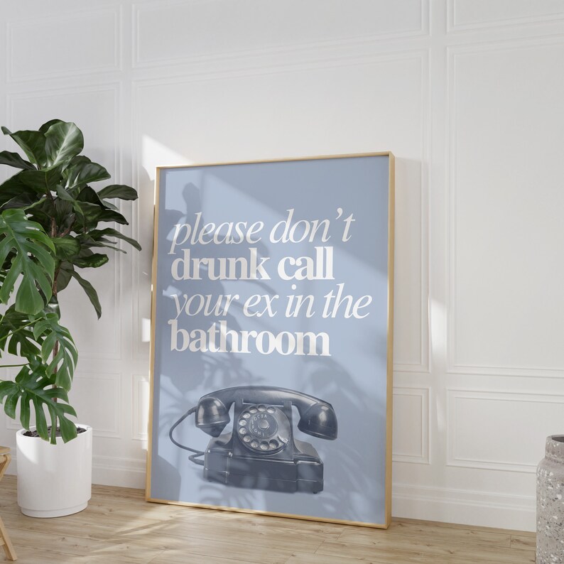 May include: A blue poster with a white frame and the text "please don't drunk call your ex in the bathroom" in white text. A black rotary phone is in the bottom center of the poster.