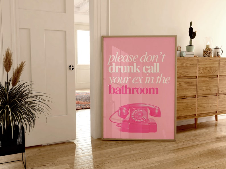 Op de afbeelding: Roze poster met de tekst "please don't drunk call your ex in the bathroom" en een roze draaischijftelefoon.