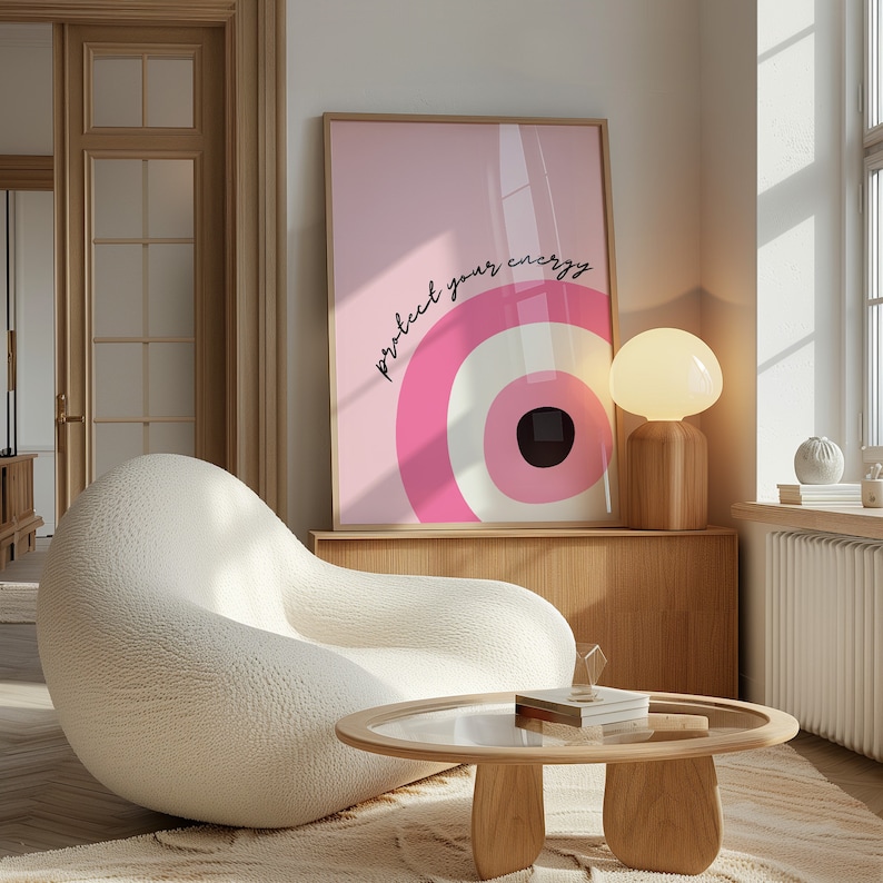 May include: A white, fluffy armchair sits in a living room with a wooden coffee table and a pink framed print with the text "protect your energy".