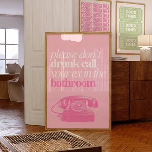 Op de afbeelding: Roze en witte poster met de tekst "please don't drunk call your ex in the bathroom" en een roze draaischijftelefoon illustratie.