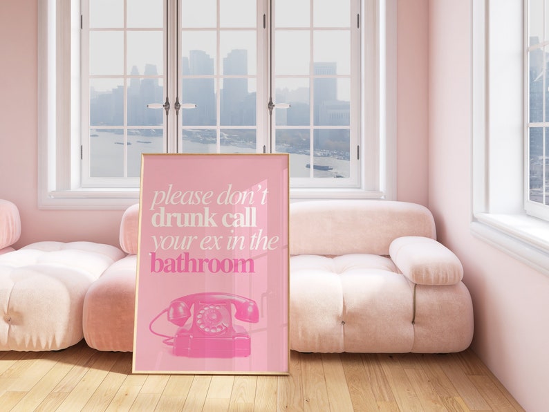 Op de afbeelding: Roze ingelijste poster met de tekst "please don't drunk call your ex in the bathroom" en een roze draaischijftelefoon illustratie.