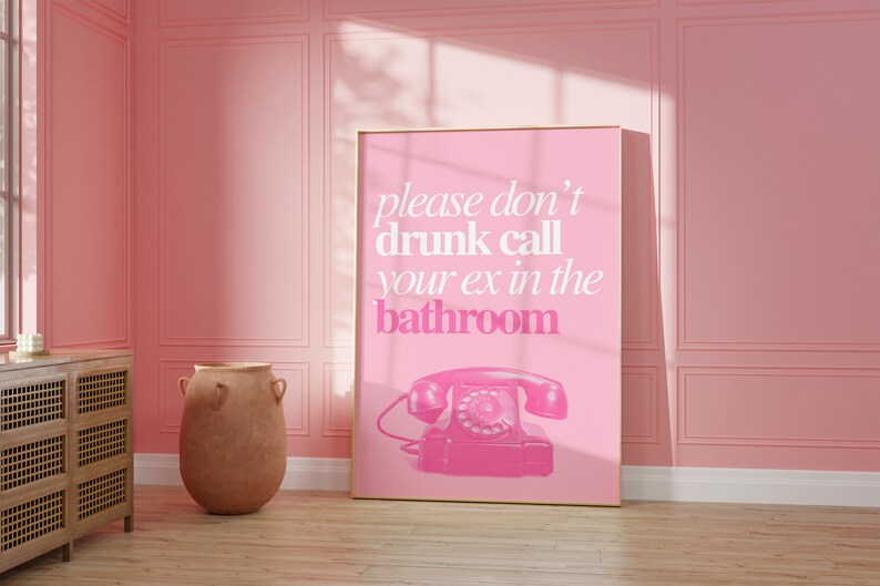 Op de afbeelding: Een roze poster met een witte rand en de tekst "please don't drunk call your ex in the bathroom" met een roze draaischijftelefoon illustratie.