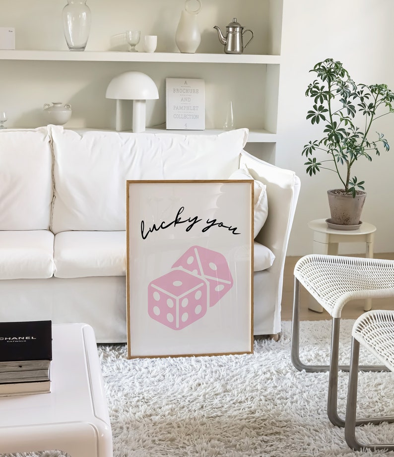 Pu&ograve; includere: Una stampa incorniciata con un design di dadi rosa e il testo "lucky you" in scrittura corsiva nera.