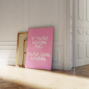 May include: A pink canvas print with a white inscription that reads "If you're reading this... you're doing amazing."