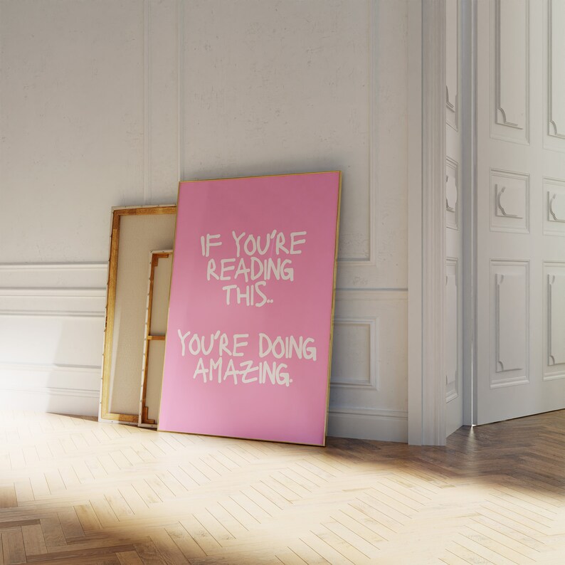 May include: A pink canvas print with a white inscription that reads "If you're reading this... you're doing amazing."