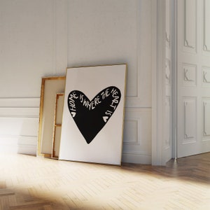 May include: A black and white print with a large heart shape. The text inside the heart reads "Home is where the heart is".