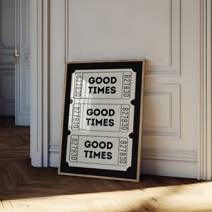 May include: A black framed poster with three white ticket-shaped designs. Each ticket has the text "GOOD TIMES" and the number "827830" printed on it.