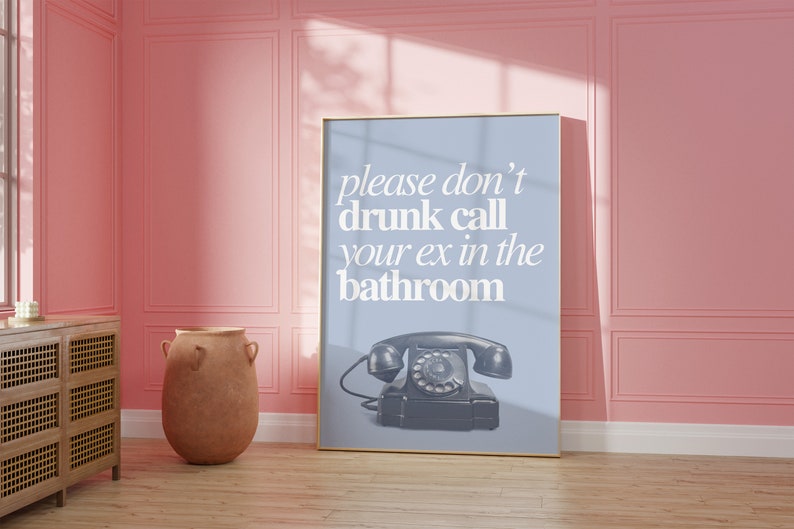 May include: A framed poster with a blue background and white text that reads "please don't drunk call your ex in the bathroom". A vintage rotary phone is pictured below the text.