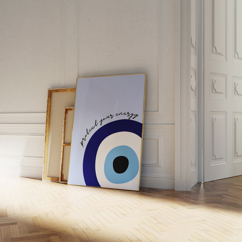 May include: A blue and white evil eye with the text "protect your energy" printed on a light blue background. The image is framed in gold.