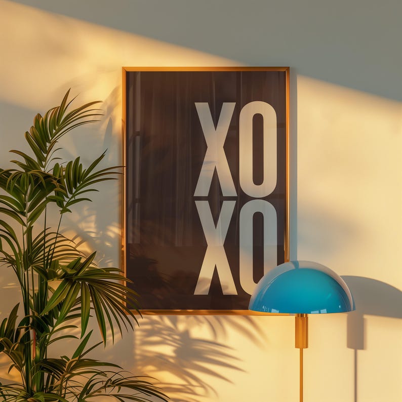 Może przedstawiać: Oprawiony wydruk artystyczny z białym tekstem "XO XO" na ciemnym tle. Niebieska lampa w kształcie kopuły znajduje się na pierwszym planie, a zielona roślina po lewej stronie obrazu.