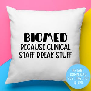 May include: White pillow with black text that reads "BIOMED BECAUSE CLINICAL STAFF BREAK STUFF".  The text is in a bold, sans-serif font.  The pillow is on a pink and yellow background.