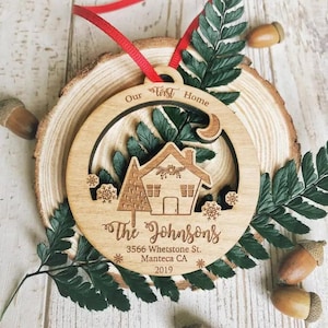 Puede incluir: Un adorno navide&ntilde;o de madera con un recorte de casa y el texto "Our First Home The Johnsons 3566 Whetstone St. Manteca CA 2019".