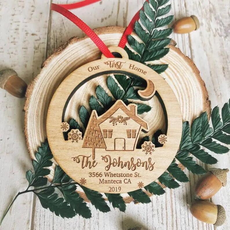 Puede incluir: Un adorno navide&ntilde;o de madera con un recorte de casa y el texto "Our First Home The Johnsons 3566 Whetstone St. Manteca CA 2019".