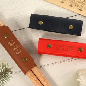 May include: Three leather cases for chopsticks, one brown with the name "D&M" engraved, one red with the text "Anna & Thomas 2024.12.20" engraved, and one blue with the name "Sophie" engraved.