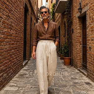 May include: A brown long-sleeved button-down shirt paired with high-waisted, wide-leg cream trousers. The outfit includes dark sunglasses and brown leather shoes. The text "STYLORDHUB" is visible in the center of the image over the trousers.