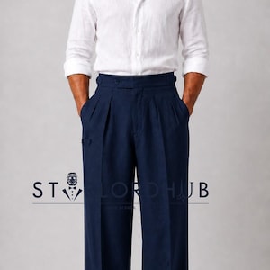 May include: A white long-sleeved button-down shirt paired with high-waisted navy blue pleated trousers featuring a wide-leg cut and cuffed hems. The text ST LORDHUB is visible across the center of the image in a dark blue font.