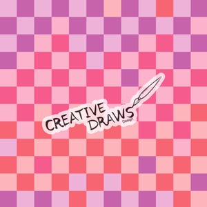 May include: A pink and purple checkered background with a white sticker that says "CREATIVE DRAWS Design" and a drawing of a paintbrush.