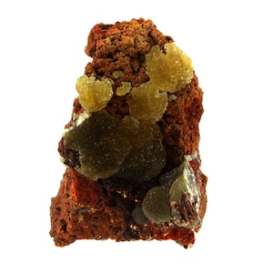 May include: A cluster of yellow and green mineral formations on a red-brown rock. The mineral formations are clustered together in a variety of shapes and sizes.