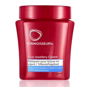 Op de afbeelding: Een rode plastic container van Connoisseurs Silver Jewellery Cleaner. Het etiket bevat de productnaam, een beschrijving in meerdere talen en een volume van 250 ml.