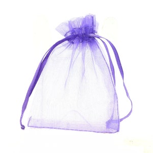 Peut inclure: Un sac cadeau en organza lavande transparent avec fermeture à cordon. Le sac est fait d'un tissu délicat et transparent et comporte des rubans lavande assortis pour l'attache. Idéal pour petits cadeaux.