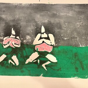 May include: Two figures in a black and white print are sitting on a green background. The figures are wearing pink swimsuits. The background is a dark gray.