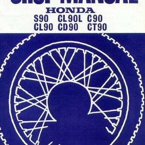 Op de afbeelding: Een blauw-wit Honda werkplaatshandboek voor de S90, CL90L, C90, CL90, CD90 en CT90 modellen. De omslag bevat een witte lijntekening van een motorwiel met spaken tegen een donkerblauwe achtergrond, met de tekst in dikke witte letters gedrukt.