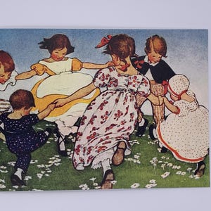 May include: Vintage postcard featuring a group of children dancing in a circle in a field of flowers. The children are wearing dresses and suits in various colors, including yellow, red, and blue. The background is a light blue sky.