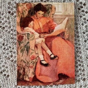 Jessie Willcox Smith Karte | 'Regentag' | Kunstkarte im Vintage-Stil mit Mutter und Kind, die zusammen ein Buch lesen. 18x13cm. Hergestellt in Großbritannien.